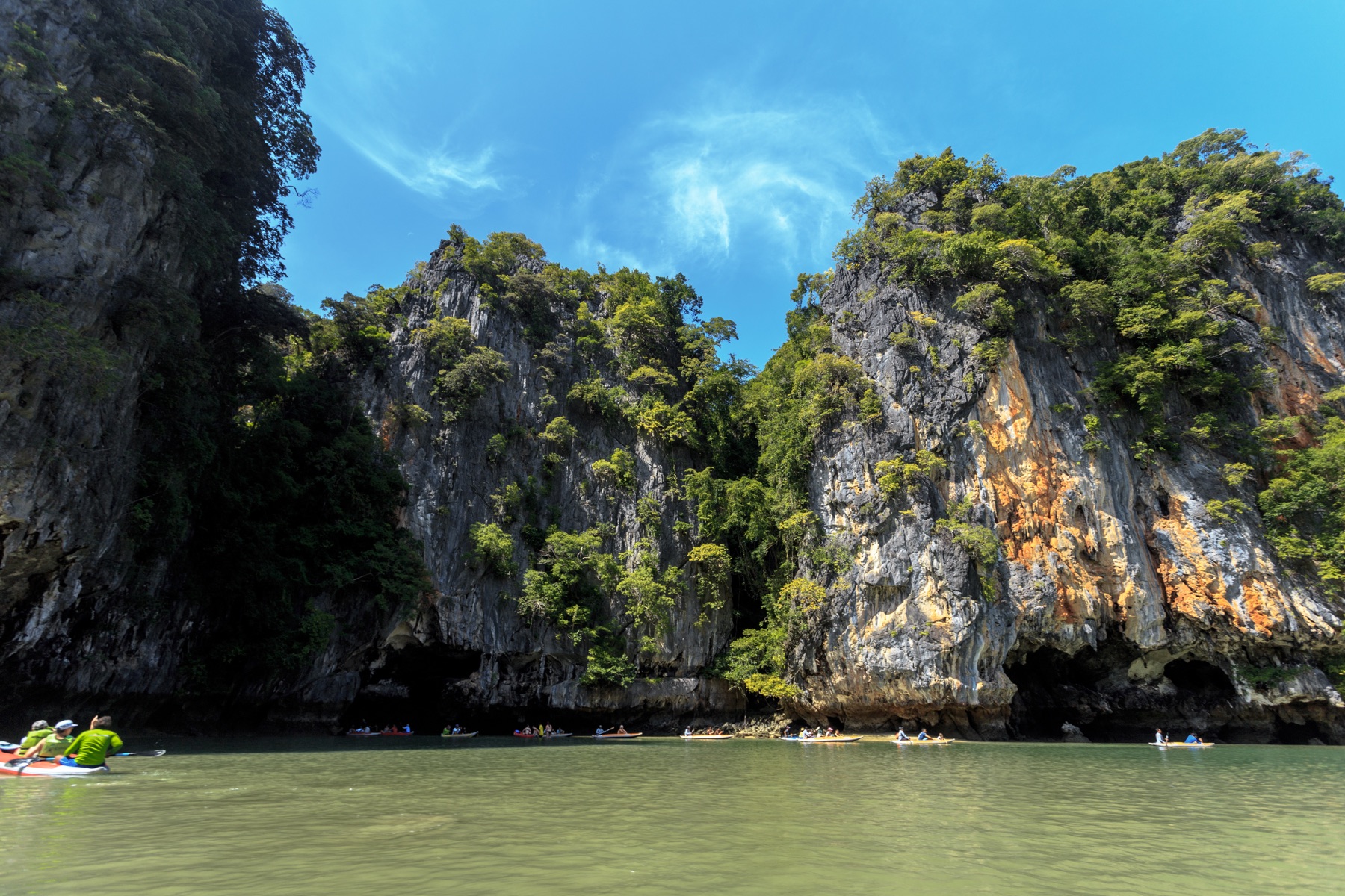 Canoes beside limestone cliffs in Thailand, illustrative stock photograph
