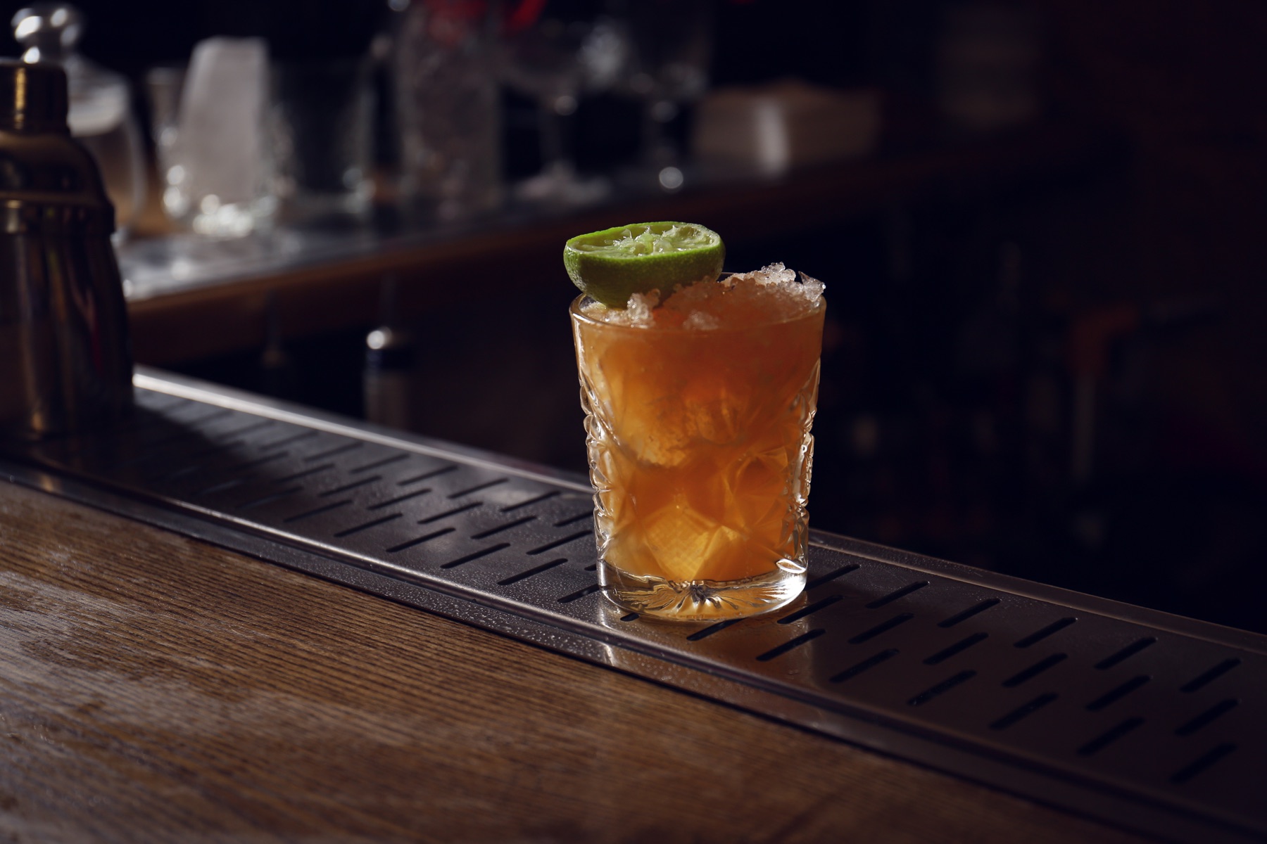 A lime cocktail on a dark bar, illustrative stock detail