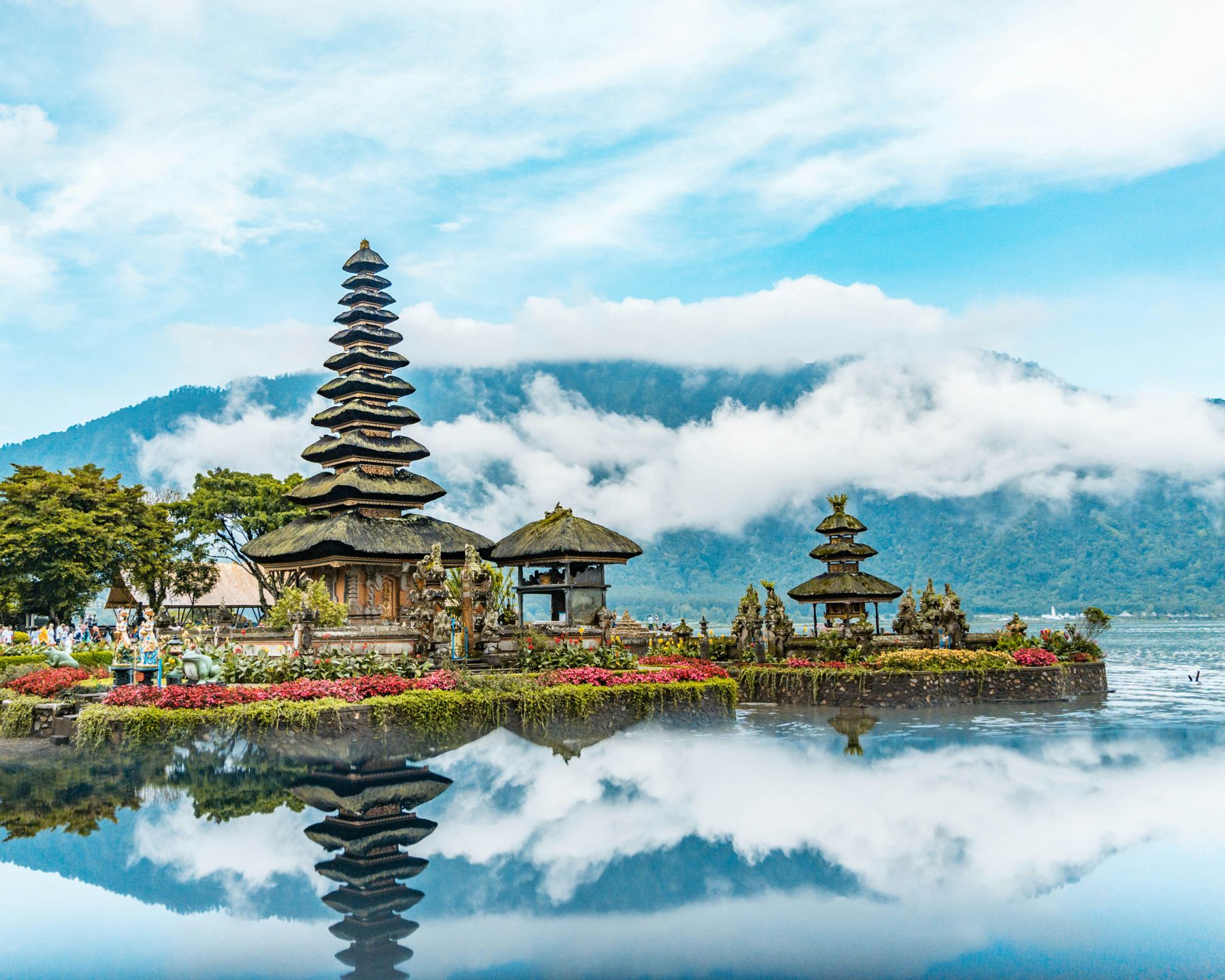 A temple on the water in the Bali highlands, with mountains behind